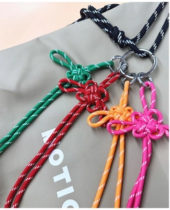 Close-up of colorful braided knot keychains with reflective thread and silver metal rings