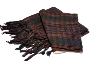 Detail of red and black checkered shemagh desert scarf with dark fringe tassels