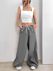 Close-up of white slim fit square neck crop top and grey drawstring cargo pants fabric detail