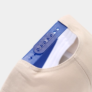Detail of snapback closure and khaki cotton twill fabric on a two-tone trucker baseball cap