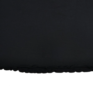 Detail shot of black fabric hem with elegant ruffle edge and textured finish