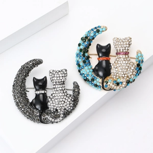 Exquisite alloy moon and cat brooches with sparkling rhinestones on white display stands