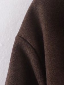Vue macro des coutures d'épaule et de la texture en laine marron du manteau long