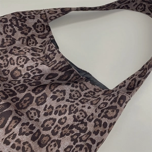 Close-up of leopard print suede tote bag showing fabric texture and shoulder strap