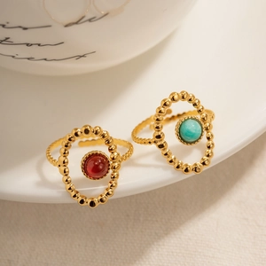 Vintage gold-plated adjustable rings with turquoise and red stones on ceramic plate