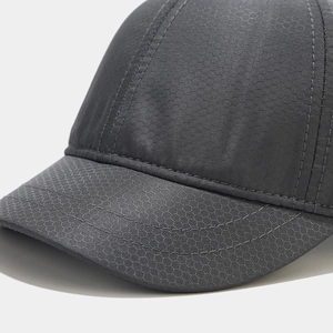 Detail of dark gray baseball cap showing hexagonal honeycomb texture and reinforced stitching