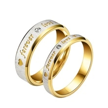 Detail of silver and gold couple rings with forever love engraving and small diamond