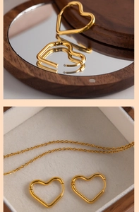Detail of heart-shaped gold hoop earrings inside a velvet-lined wooden jewelry box
