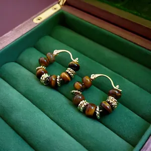 Vintage hoop earrings with gold-plated tiger eye beads on deep green velvet lining