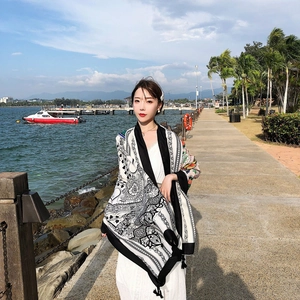 Detail view of ethnic style black and white shawl with colorful pattern and tassels