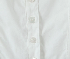 Détail macro du tissu en coton et lin blanc avec boutons assortis à quatre trous