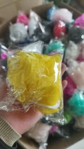 Detailweergave van een gele badspons van mesh in een individuele plastic zakverpakking