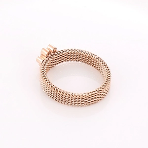 Macro view of rose gold woven mesh texture and decorative ring settings detail