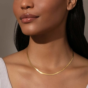Polished gold stainless steel flat snake chain necklace worn on model neck