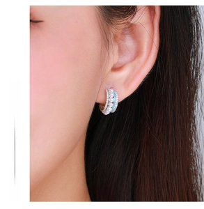 Détail de créoles en argent s925 avec turquoise, perles et cristaux sur modèle féminin