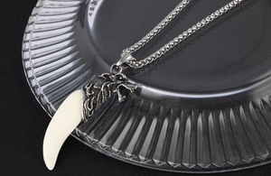 Dettaglio della collana testa di lupo argento con dente in resina avorio