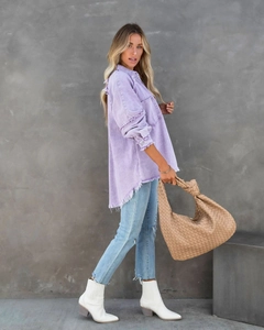 Detailansicht der lila Jeansjacke mit Fransen und gewebter Lederhandtasche