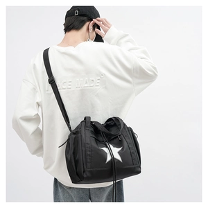 Man wearing a black crossbody bag with white star logo and adjustable strap on back