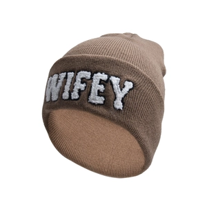 Close-up of khaki knitted beanie featuring white fuzzy WIFEY letter embroidery