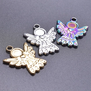 Macro detail of angel wing pendants in gold, silver and rainbow plated stainless steel