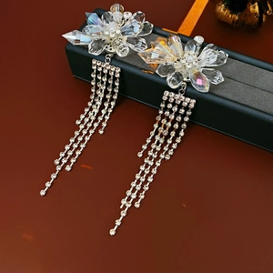 Macro detail of crystal flower earrings with sparkling rhinestone tassels on jewelry box