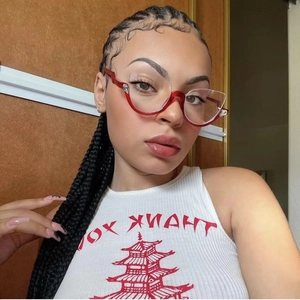 Close-up of red cat-eye semi-rimless glasses with silver accents worn by a model