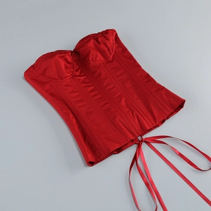 Détail du haut corset rouge avec structure à baleines et laçage en rubans de satin brillant