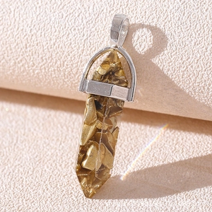 Detail of bullet-shaped resin pendant filled with gold stones and silver metal clasp