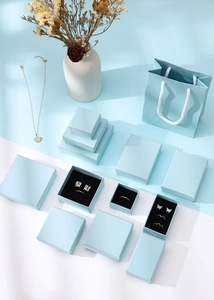 Close-up of premium light blue jewelry boxes and matching paper gift bag set