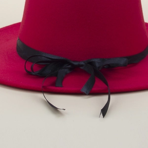 Detailed view of dark red wool fedora featuring a black satin bow with pearl accents