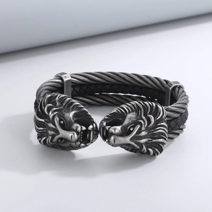Macro shot of silver lion head bracelet showing double twisted cable steel wire details
