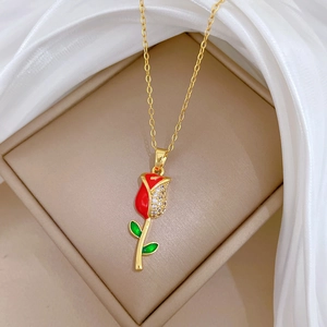 Dettaglio ravvicinato di una collana a rosa dorata con smalto rosso e cristalli lucidi
