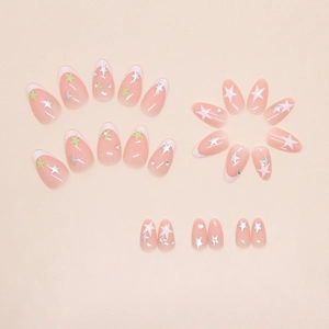 Detail of nude pink press-on nails with white French tips and silver star patterns