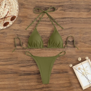 Flat lay of olive green ribbed bikini set with halter top on rustic wooden surface