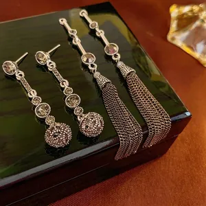 Vintage silver tassel drop earrings with hollow spheres and crystals on jewelry box