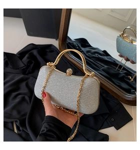 Detail of silver glitter evening clutch bag with gold handle and sparkling rhinestone clasp