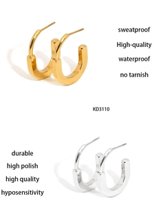 Close-up of minimalist gold and silver U-shaped earrings with high-polished metallic finish