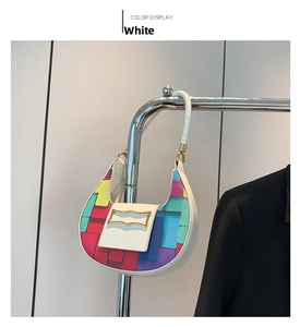 Detailed view of white crescent bag featuring colorful geometric blocks and gold buckle