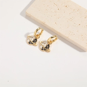 Detail of gold planet earrings with black and white enamel and sparkling crystals