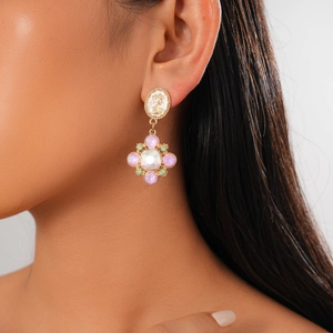 Close-up of vintage cameo earrings with floral crystal charms on a model's ear