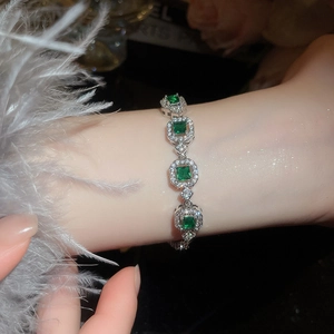 French palace style bracelet with emerald cut green gemstones and shimmering diamonds