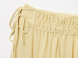 Detail of high waist elastic smocking and side tie on beige chiffon ruffled skirt