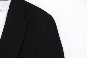Détail du revers à pointe et de l'épaule rembourrée sur un blazer noir croisé chic
