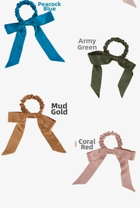 Close-up of four colorful silk hair scrunchies with long ribbons on white background