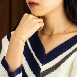 Elegante set di bracciale e collana in titanio placcato oro 18 carats indossato da una modella