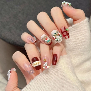 Handmade Christmas press-on nails with 3D reindeer, festive red plaid, and gold bow charms