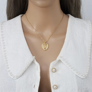 Elegante collana dorata con ciondolo a cuore farfalla e ali d'angelo su una modella