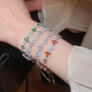 Detail of leaf bracelets with colorful marquise stones on an elegant sleeve cuff