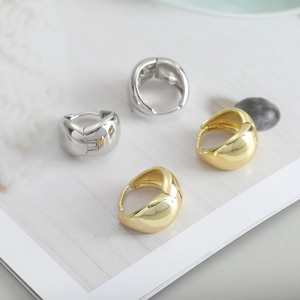 Close-up of polished water drop earrings with S925 silver stamp in gold and silver