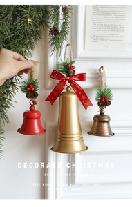 Détail de trois cloches de Noël décoratives avec aiguilles de pin et baies rouges